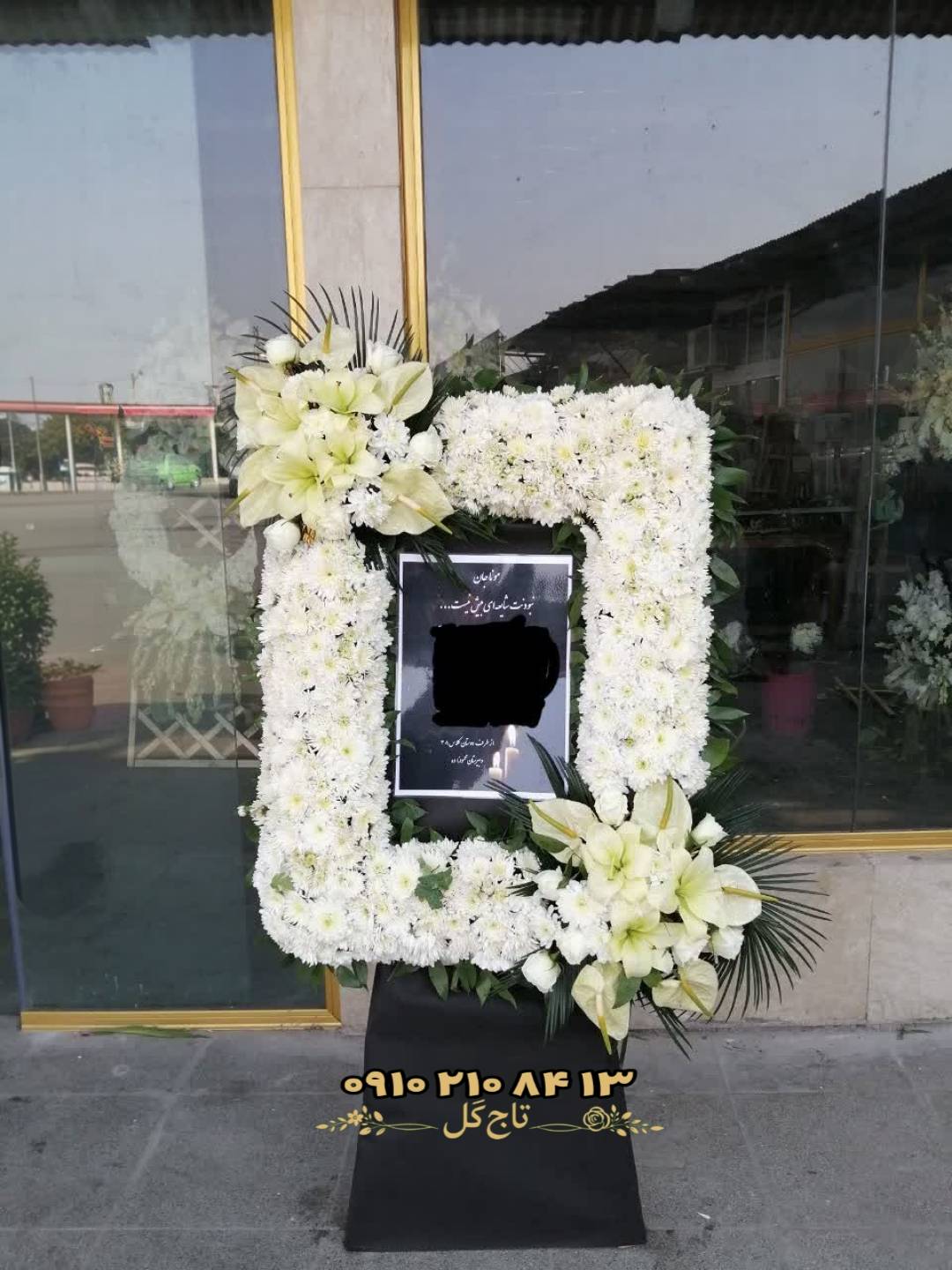 فریم گل ایستاده دور قاب عکس یادبود و ترحیم با گل‌های داوودی، آنتوریوم و لیلیوم سفید کد۱۱۷۴